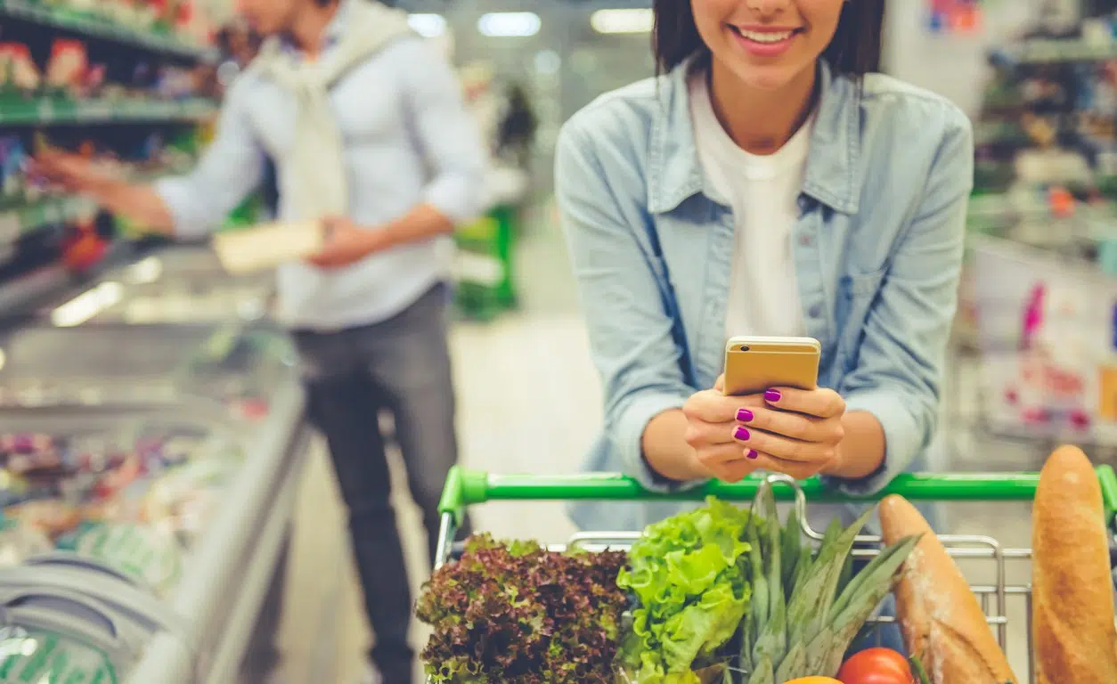 Consultation de son appareil mobile au supermarché